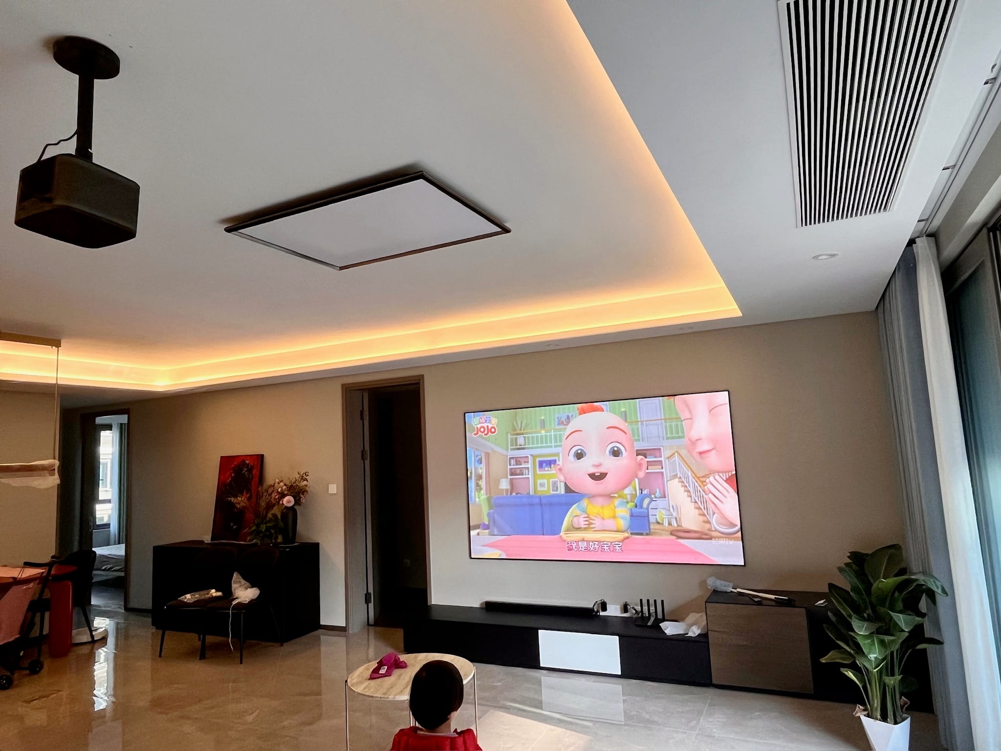 孩子在明亮客厅观看固定大屏动画